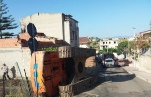 Cagliari, escavatore si ribalta durante una manovra: danneggiata un’auto